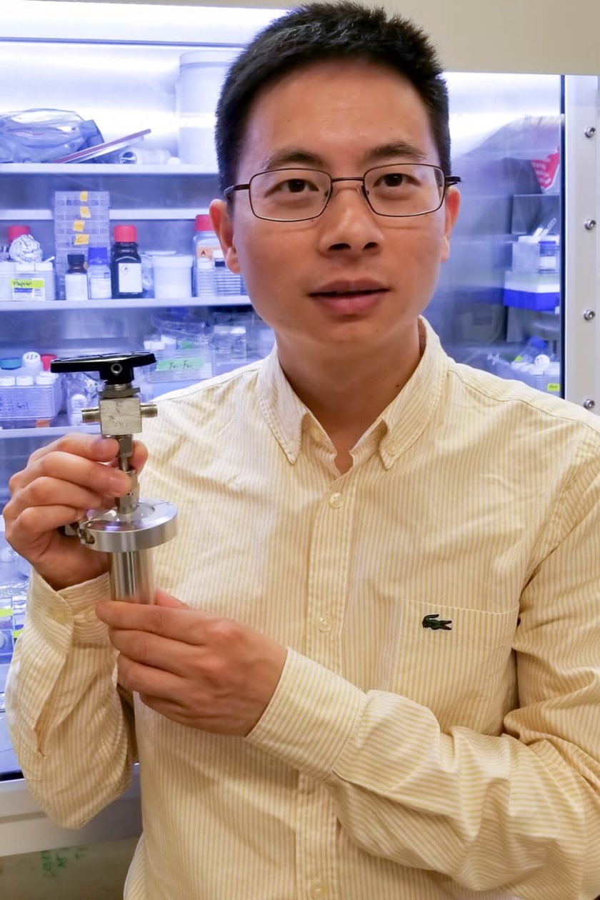 Postdoctoral scholar Wei Chen holds a prototype of what could one day be a ginormous battery designed to store solar and wind energy thanks to a water-based chemical reaction developed in the lab of Stanford materials scientist Yi Cui. (Photo by Jinwei Xu)