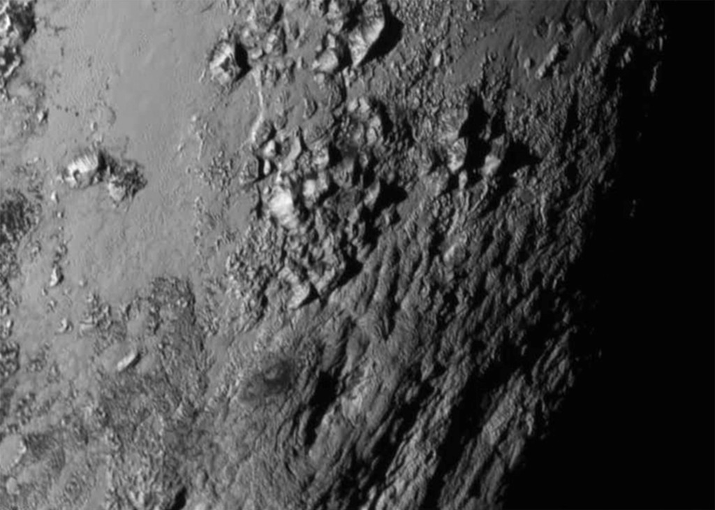 Detail oblasti v blízkosti rovníku Pluta, ukazující řadu mladých hor vysokých okolo 3 500 m nad povrchem ledové planety. Zdroj: NASA