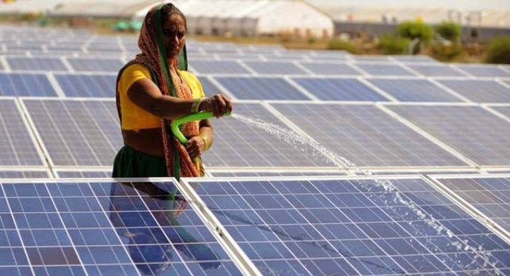 Indická žena čistí fotovoltaické panely. Zdroj: Getty Images