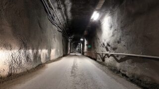 Obr�zek p��stupov�ho tunelu hlubinn�ho �lo�i�t� Onkalo ve Finsku zobrazuj�c� betonem vyztu�enou podzemn� chodbu vedouc� do skaln�ho masivu