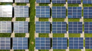 Obr�zek fotovoltaick�ch panel� instalovan�ch v �ad�ch na sol�rn� elektr�rn�